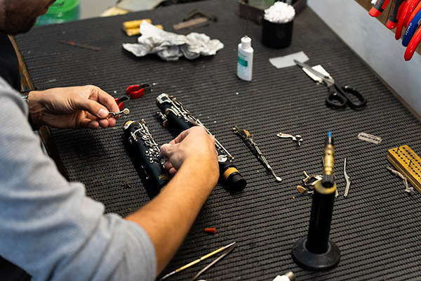 Technician repairing woodwind instrument in Pieor's Music Store, Bayonne, NJ